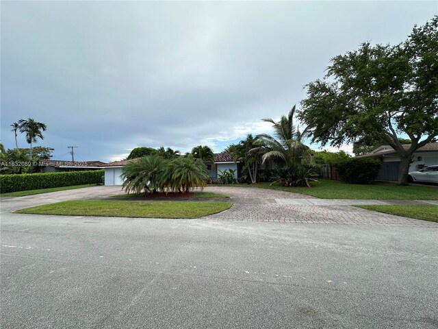 8821 SW 87th St, Miami, FL 33173 - obstructed view of property with curved driveway and a garage