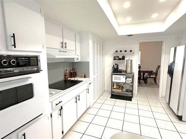 8821 SW 87th St, Miami, FL 33173 - kitchen featuring under cabinet range hood, white appliances, white cabinets, light tile patterned floors, and recessed lighting