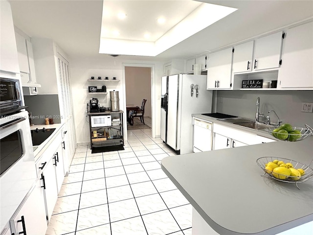 8821 SW 87th St, Miami, FL 33173 - kitchen featuring white appliances, a tray ceiling, white cabinetry, recessed lighting, and a peninsula