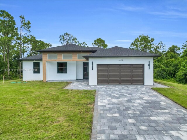 1018 Calvin Ave, Lehigh Acres, FL 33972 - prairie-style home with stucco siding, an attached garage, a front yard, and decorative driveway