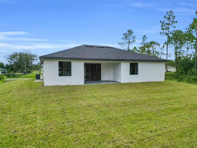 1018 Calvin Ave, Lehigh Acres, FL 33972 - rear view of house with stucco siding, a yard, and a shingled roof