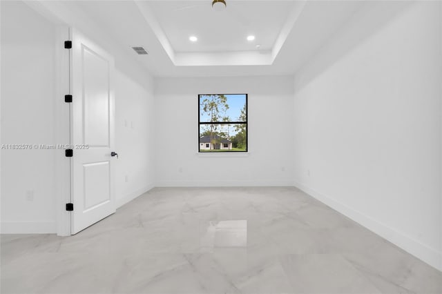 1018 Calvin Ave, Lehigh Acres, FL 33972 - spare room featuring light marble finish flooring, recessed lighting, and a tray ceiling