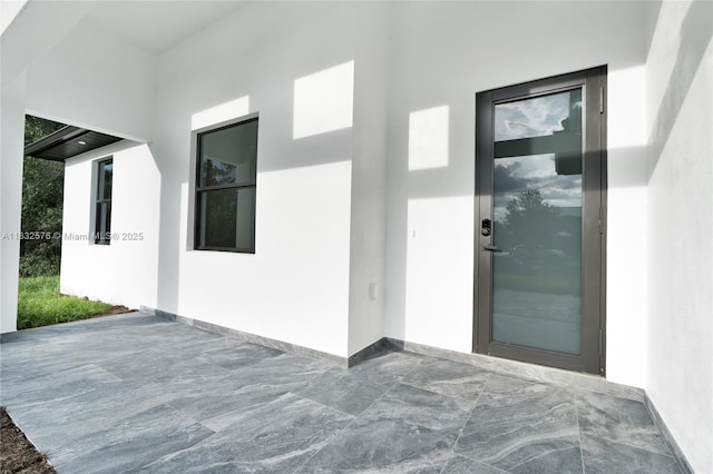 1018 Calvin Ave, Lehigh Acres, FL 33972 - doorway to property featuring stucco siding and a patio area