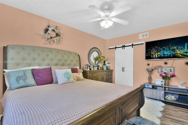 1419 Avon Ln Unit 216, North Lauderdale, FL 33068 - bedroom featuring a barn door, wood finished floors, and a ceiling fan