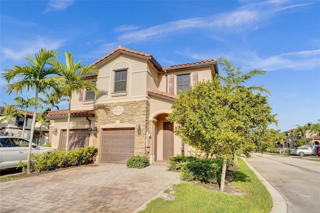 5013 Vulcan Way, Davie, FL 33314 - view of front of home featuring a tiled roof, an attached garage, stucco siding, decorative driveway, and stone siding