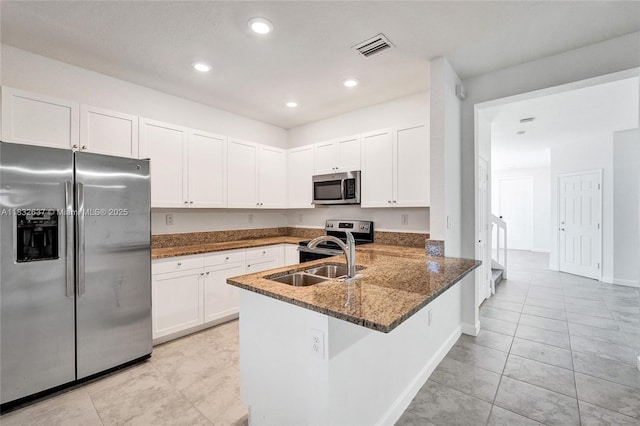 5013 Vulcan Way, Davie, FL 33314 - kitchen with appliances with stainless steel finishes, dark stone counters, white cabinetry, a peninsula, and light tile patterned floors