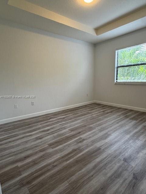 5013 Vulcan Way, Davie, FL 33314 - empty room with a tray ceiling and dark wood-style flooring