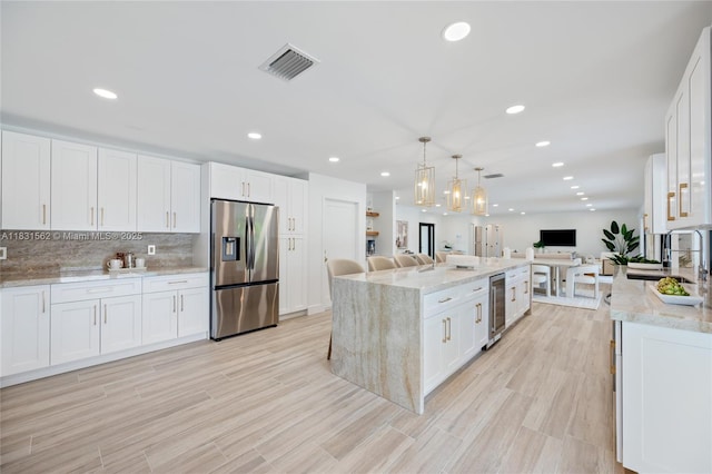 10704 SW 133rd Ter, Miami, FL 33176 - kitchen featuring stainless steel fridge with ice dispenser, wine cooler, open floor plan, white cabinets, and recessed lighting