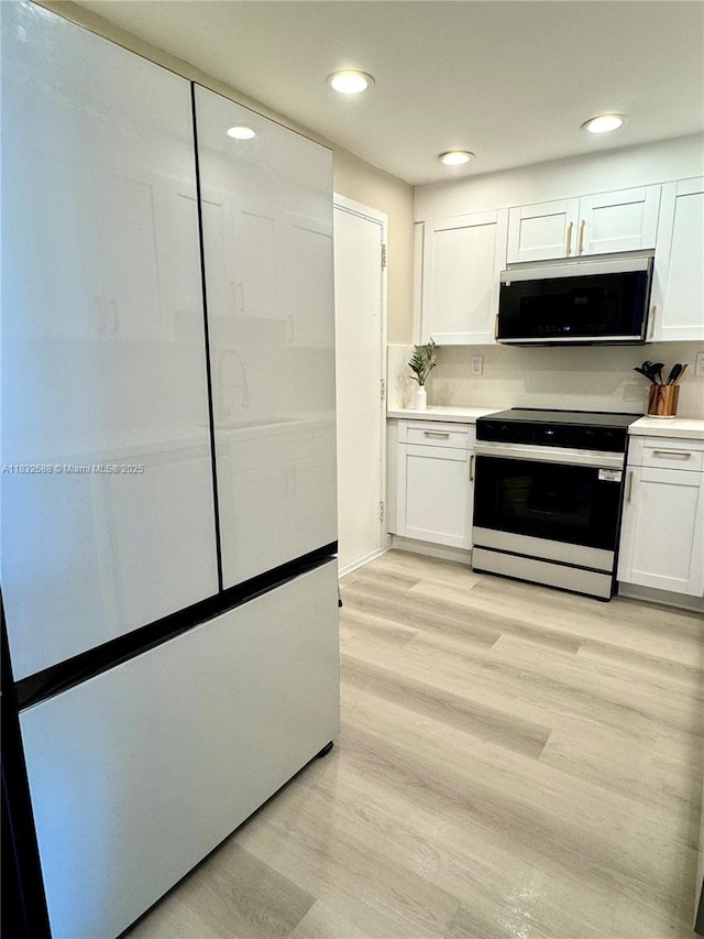 300 Bayview Dr Unit 1801, Sunny Isles Beach, FL 33160 - kitchen with electric stove, white cabinetry, light wood-style floors, light countertops, and recessed lighting
