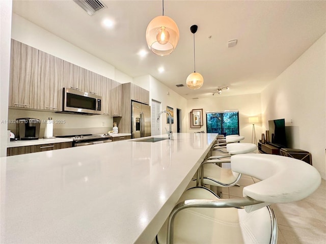 8031 NW 104th Ave Unit 21, Doral, FL 33178 - kitchen featuring stainless steel appliances, a kitchen breakfast bar, light countertops, and modern cabinets