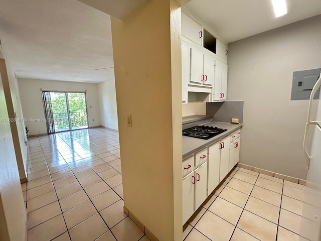 3181 SW 13th St Unit 401, Miami, FL 33145 - kitchen with black cooktop, light tile patterned floors, white cabinets, open floor plan, and refrigerator