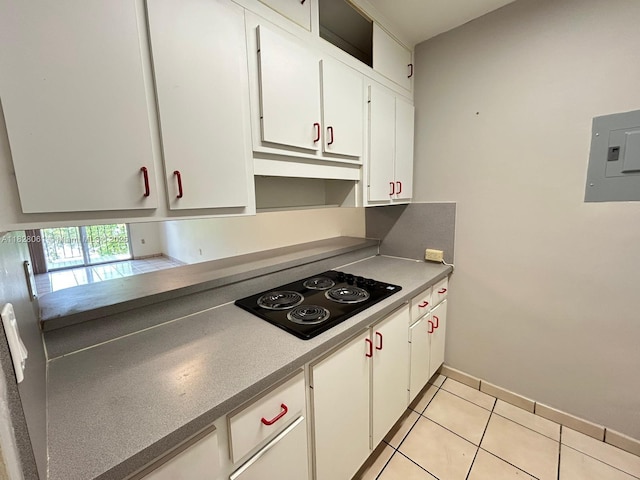 3181 SW 13th St Unit 401, Miami, FL 33145 - kitchen featuring black electric stovetop, white cabinetry, electric panel, and light tile patterned flooring