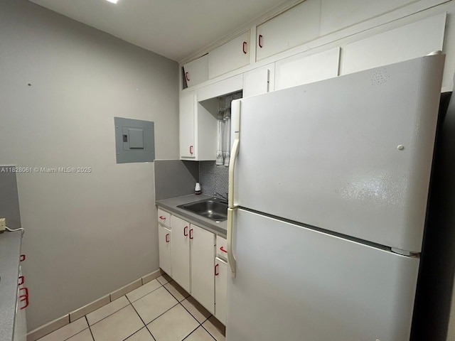 3181 SW 13th St Unit 401, Miami, FL 33145 - kitchen with freestanding refrigerator, electric panel, white cabinets, and light tile patterned floors