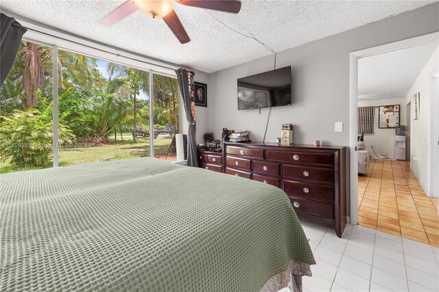 20350 SW 182nd Ave, Miami, FL 33187 - kitchen featuring freestanding refrigerator, black microwave, blue cabinets, a textured ceiling, and light tile patterned floors