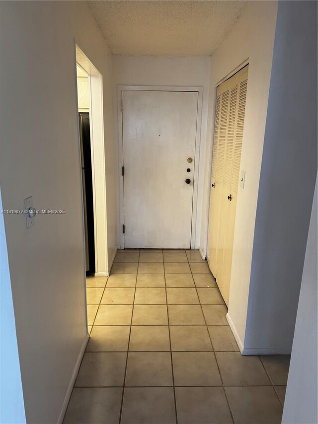 16851 NE 23rd Ave Unit A516, North Miami Beach, FL 33160 - corridor featuring light tile patterned floors and a textured ceiling
