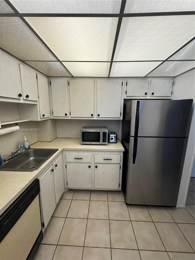 16851 NE 23rd Ave Unit A516, North Miami Beach, FL 33160 - kitchen with stainless steel appliances, a paneled ceiling, light countertops, and light tile patterned floors