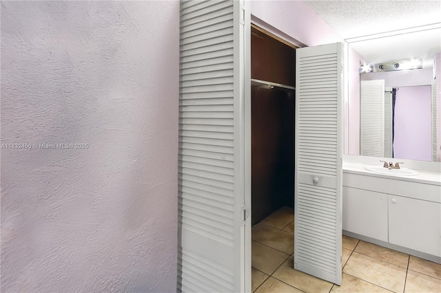 1755 W 60th St Unit D206, Hialeah, FL 33012 - bathroom featuring tile patterned flooring, vanity, a closet, and a textured ceiling