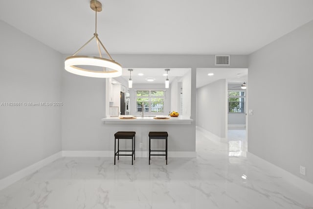 12500 SW 6th St Unit 206N, Pembroke Pines, FL 33027 - kitchen featuring stainless steel refrigerator, a kitchen breakfast bar, healthy amount of natural light, light marble finish flooring, and recessed lighting