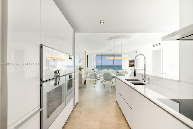10203 Collins Ave Unit 1003, Bal Harbour, FL 33154 - kitchen with modern cabinets, white cabinets, light countertops, extractor fan, and oven