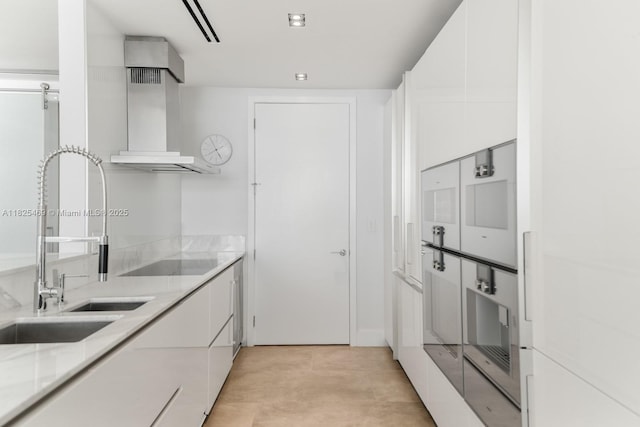 10203 Collins Ave Unit 1003, Bal Harbour, FL 33154 - kitchen with wall chimney range hood, white cabinets, modern cabinets, light stone counters, and black electric cooktop