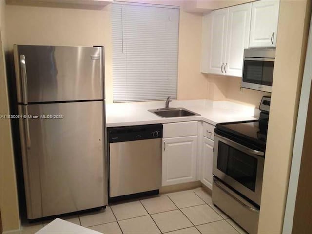 6045 NW 186th St Unit 103, Hialeah, FL 33015 - kitchen featuring stainless steel appliances, white cabinetry, light tile patterned flooring, and light countertops