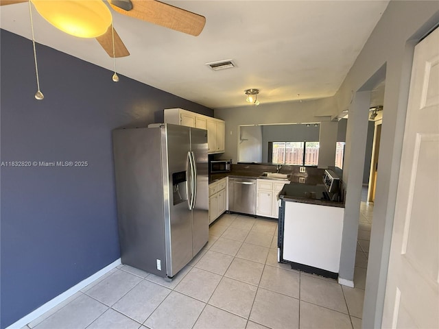 1965 SW 81st Way, Davie, FL 33324 - kitchen with appliances with stainless steel finishes, dark countertops, light tile patterned flooring, a ceiling fan, and white cabinetry
