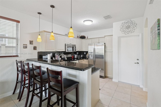 14842 SW 22nd Ter, Miami, FL 33185 - kitchen with stainless steel appliances, a peninsula, a breakfast bar area, and light tile patterned floors