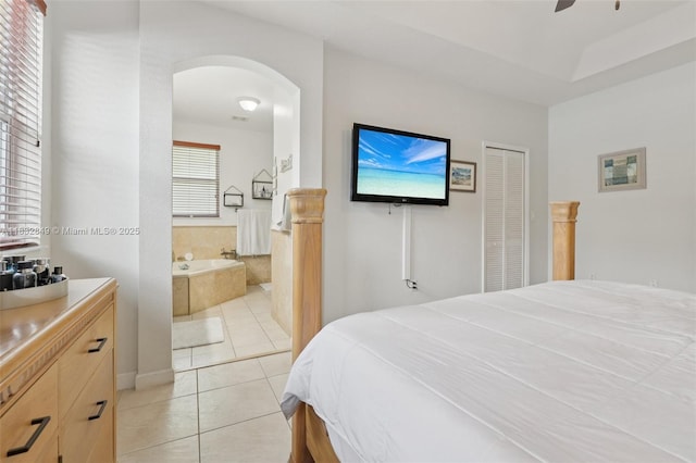 14842 SW 22nd Ter, Miami, FL 33185 - bedroom with arched walkways, light tile patterned flooring, connected bathroom, ceiling fan, and a closet