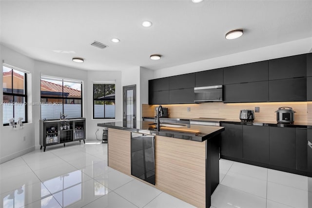 1005 NW 100th Ave, Miami, FL 33172 - kitchen featuring dark cabinetry, backsplash, modern cabinets, recessed lighting, and light tile patterned floors