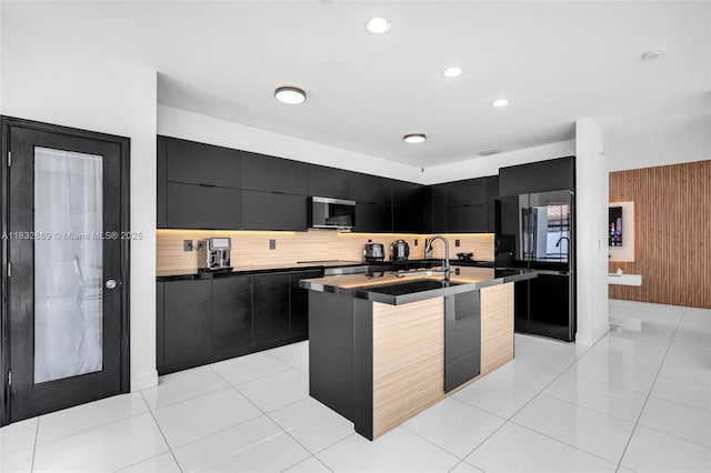 1005 NW 100th Ave, Miami, FL 33172 - kitchen featuring dark cabinetry, modern cabinets, dark countertops, tasteful backsplash, and freestanding refrigerator