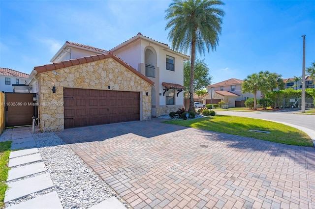 1005 NW 100th Ave, Miami, FL 33172 - mediterranean / spanish-style home with stone siding, decorative driveway, a garage, a tiled roof, and stucco siding