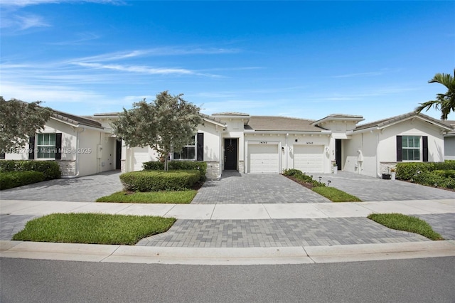 14549 Bretton Woods Trce, Delray Beach, FL 33446 - view of front of home featuring an attached garage, decorative driveway, stucco siding, and stone siding