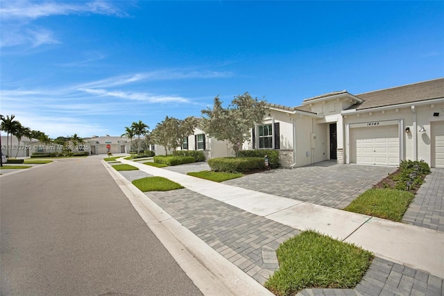 14549 Bretton Woods Trce, Delray Beach, FL 33446 - view of front of house featuring driveway, an attached garage, stucco siding, and a residential view