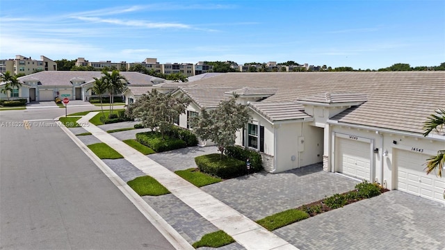14549 Bretton Woods Trce, Delray Beach, FL 33446 - view of front of property with an attached garage, decorative driveway, a tile roof, a residential view, and stucco siding