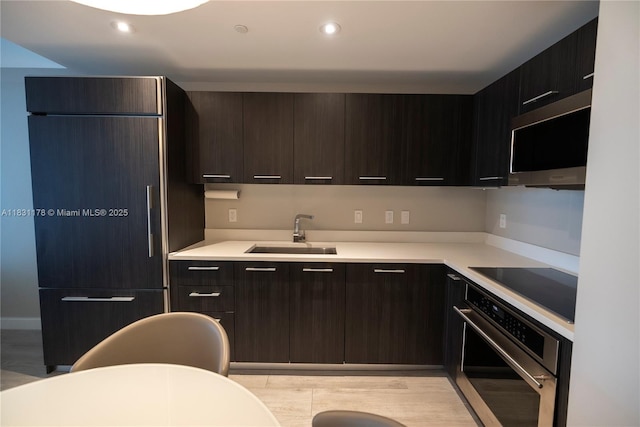 45 SW 9th St Unit 1705, Miami, FL 33130 - kitchen with stainless steel appliances, light countertops, modern cabinets, dark brown cabinets, and light wood-type flooring
