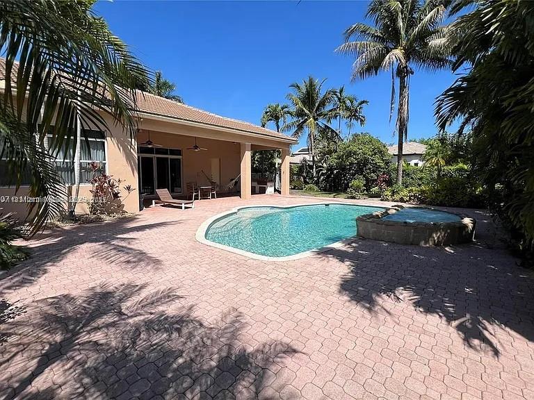 3230 SW 139th Ter, Davie, FL 33330 - view of swimming pool featuring ceiling fan, a patio area, and a pool with connected hot tub