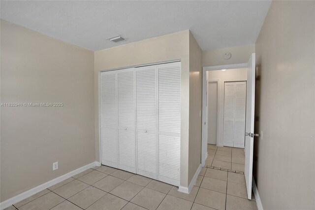 1200 W 31st St, Riviera Beach, FL 33404 - unfurnished bedroom featuring light tile patterned floors and a closet