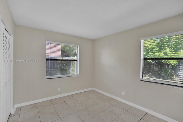 1200 W 31st St, Riviera Beach, FL 33404 - spare room featuring light tile patterned flooring and baseboards