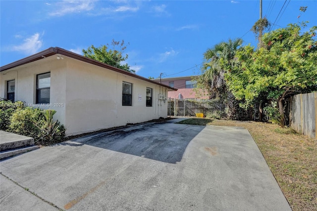 1200 W 31st St, Riviera Beach, FL 33404 - view of side of home with a fenced backyard, stucco siding, and a patio area