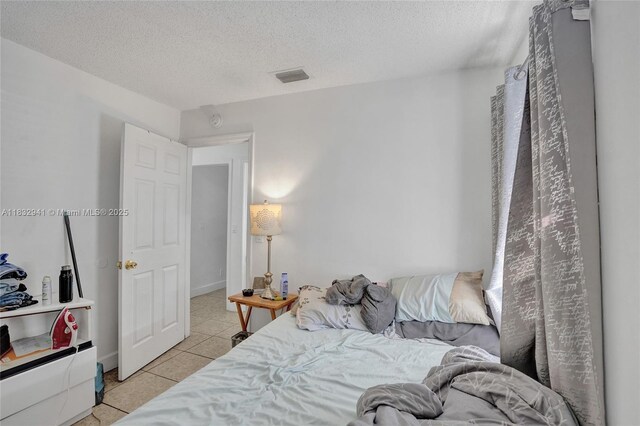 1200 W 31st St, Riviera Beach, FL 33404 - bedroom featuring light tile patterned floors and a textured ceiling