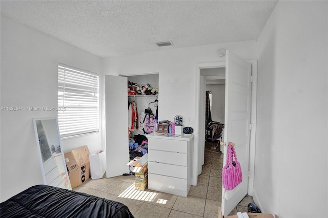 1200 W 31st St, Riviera Beach, FL 33404 - bedroom with light tile patterned floors, a textured ceiling, and a closet