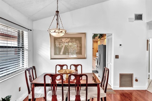 631 SW 113th Ave, Pembroke Pines, FL 33025 - dining area featuring wood finished floors, lofted ceiling, and a textured ceiling
