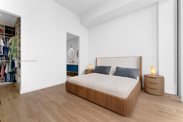 2655 S Bayshore Dr Unit 2012, Miami, FL 33133 - bedroom featuring a walk in closet, a closet, wood finished floors, and connected bathroom