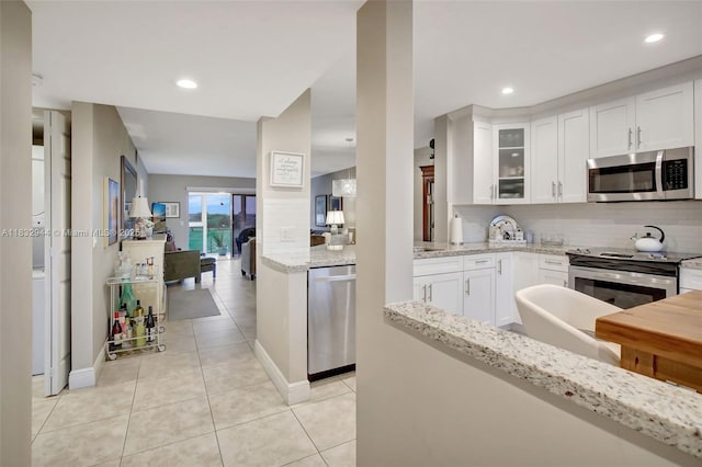 800 SW 125th Way Unit 405O, Pembroke Pines, FL 33027 - kitchen with appliances with stainless steel finishes, decorative backsplash, light tile patterned flooring, glass insert cabinets, and white cabinets