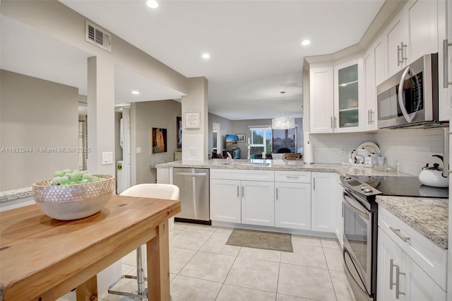 800 SW 125th Way Unit 405O, Pembroke Pines, FL 33027 - kitchen featuring appliances with stainless steel finishes, light tile patterned floors, glass insert cabinets, white cabinetry, and recessed lighting