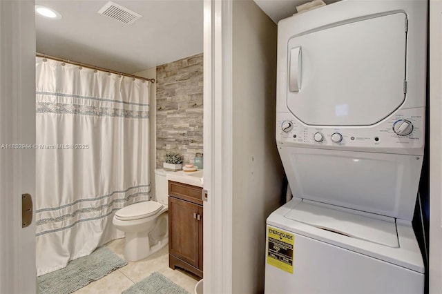 800 SW 125th Way Unit 405O, Pembroke Pines, FL 33027 - laundry room with stacked washer / dryer, light tile patterned flooring, and tile walls