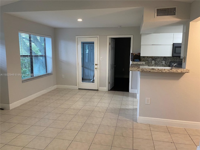 15661 SW 104th Ter Unit 3112, Miami, FL 33196 - kitchen with black microwave, white cabinets, light tile patterned floors, recessed lighting, and light stone countertops