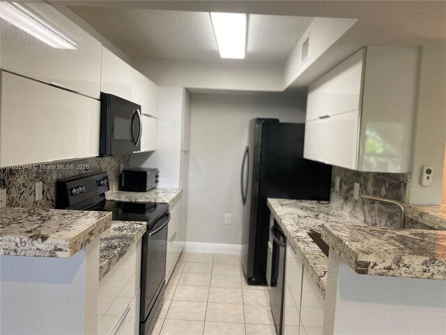15661 SW 104th Ter Unit 3112, Miami, FL 33196 - kitchen with black appliances, decorative backsplash, white cabinets, and light tile patterned flooring