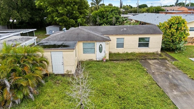 519 N 60th Way, Hollywood, FL 33024 - view of front of house featuring a shingled roof and a front yard