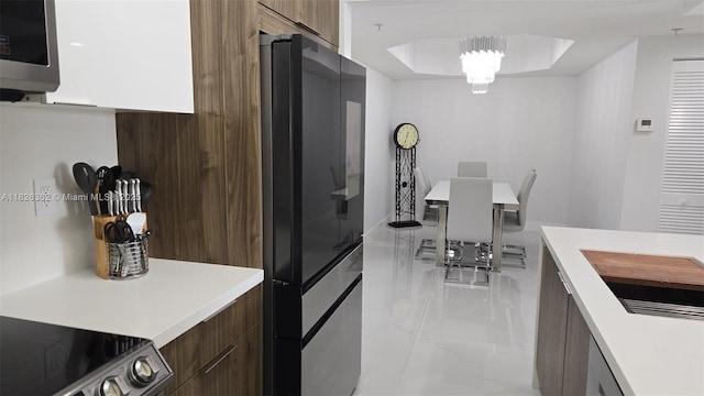 230 SW 117th Ter, Pembroke Pines, FL 33025 - kitchen featuring modern cabinets, refrigerator, light countertops, stainless steel microwave, and dark brown cabinetry